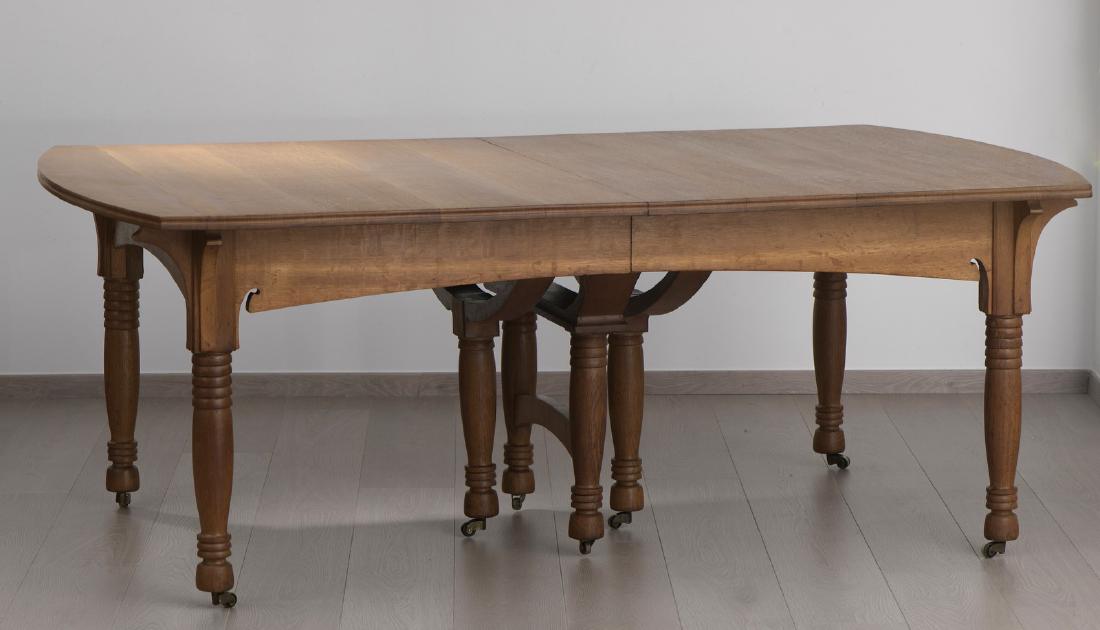 GUSTAVE SERRURIER-BOVY (1858-1910) Table en chaî: GUSTAVE SERRURIER-BOVY (1858-1910) Table en chaîne et six chaises. Table sur huit pieds reposant sur des roulettes en laiton , à système à rallonge pour douze personnes. Inscriptio