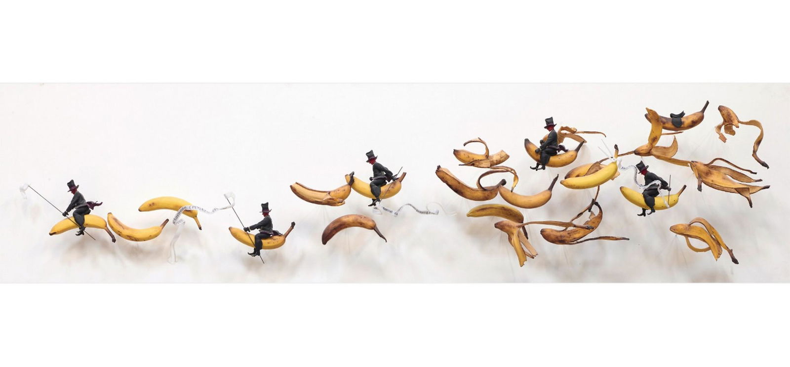 Gilles BARBIER (Né en 1965): BANANA RIDERS Résine peinte, plastique et métal monté sur panneau peint Titré au dos 60 x 240 x 35 cm – 23.6 x 94.5 x 13.8 in.