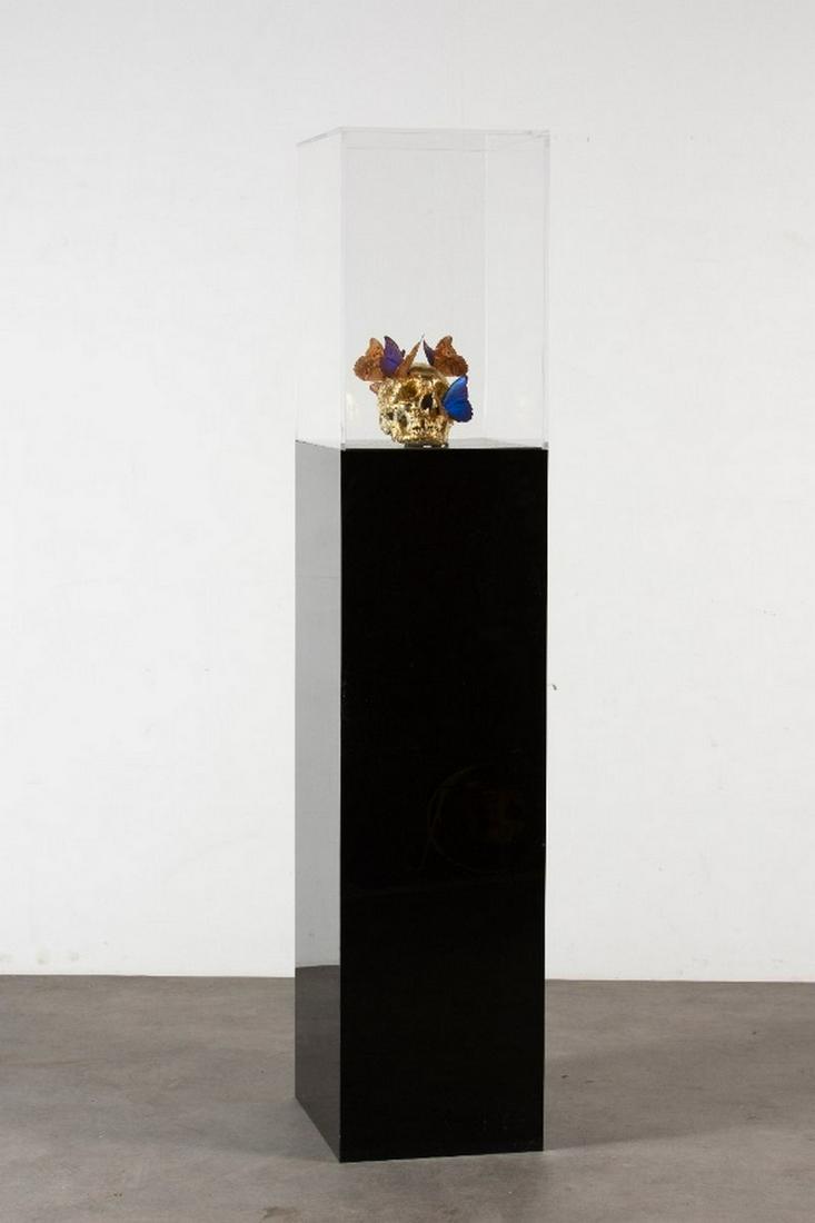 Philippe PASQUA (Né en 1965) Vanité aux: Philippe PASQUA (Né en 1965) Vanité aux papillons Crâne en résine recouvert à la feuille d’or et papillons naturalisés reposant sur un socle recouvert d’un mi