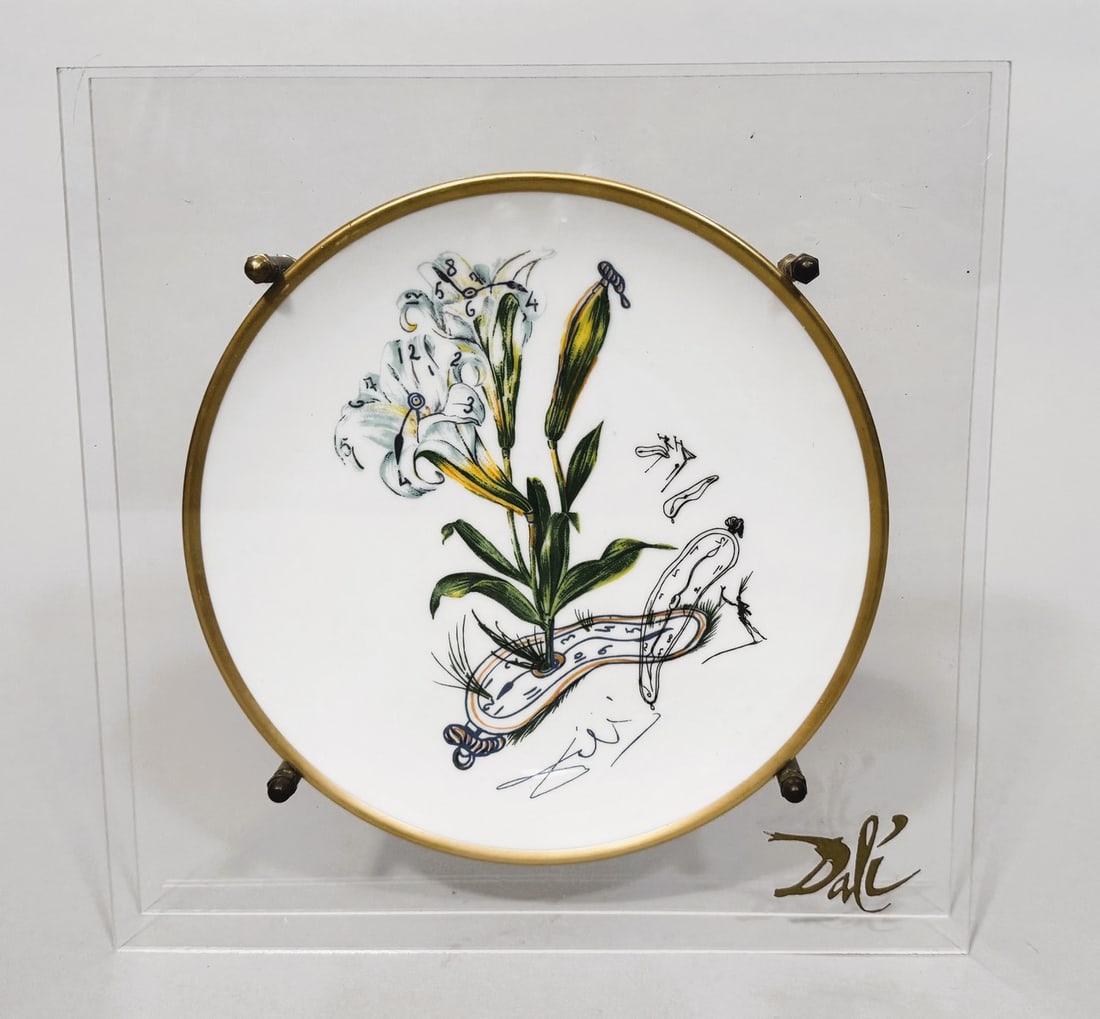 Salvador DALI (1904-1989).: Salvador DALI (1904-1989). "Lilium Longiflorum vel Tempus". 1981-1983. Assiette réalisée en porcelaine, peinte en polychromie, bordure dorée, plexiglas, laiton. De la série "Les Fl