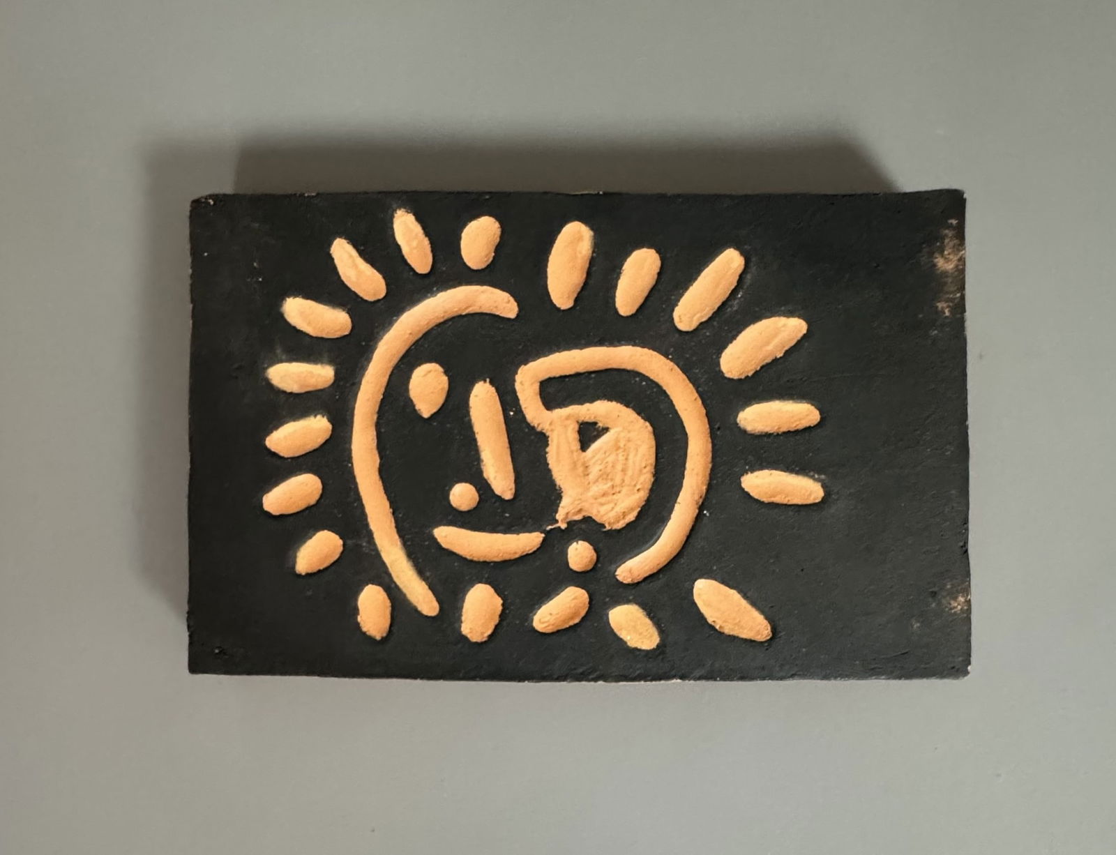 Pablo PICASSO (1881-1973) « Petit soleil »: Pablo PICASSO (1881-1973) « Petit soleil » Plaque en terre cuite avec engobe noir estampillé, marquée et numérotée « Madoura Plein Feu / Empreinte Originale de Picas