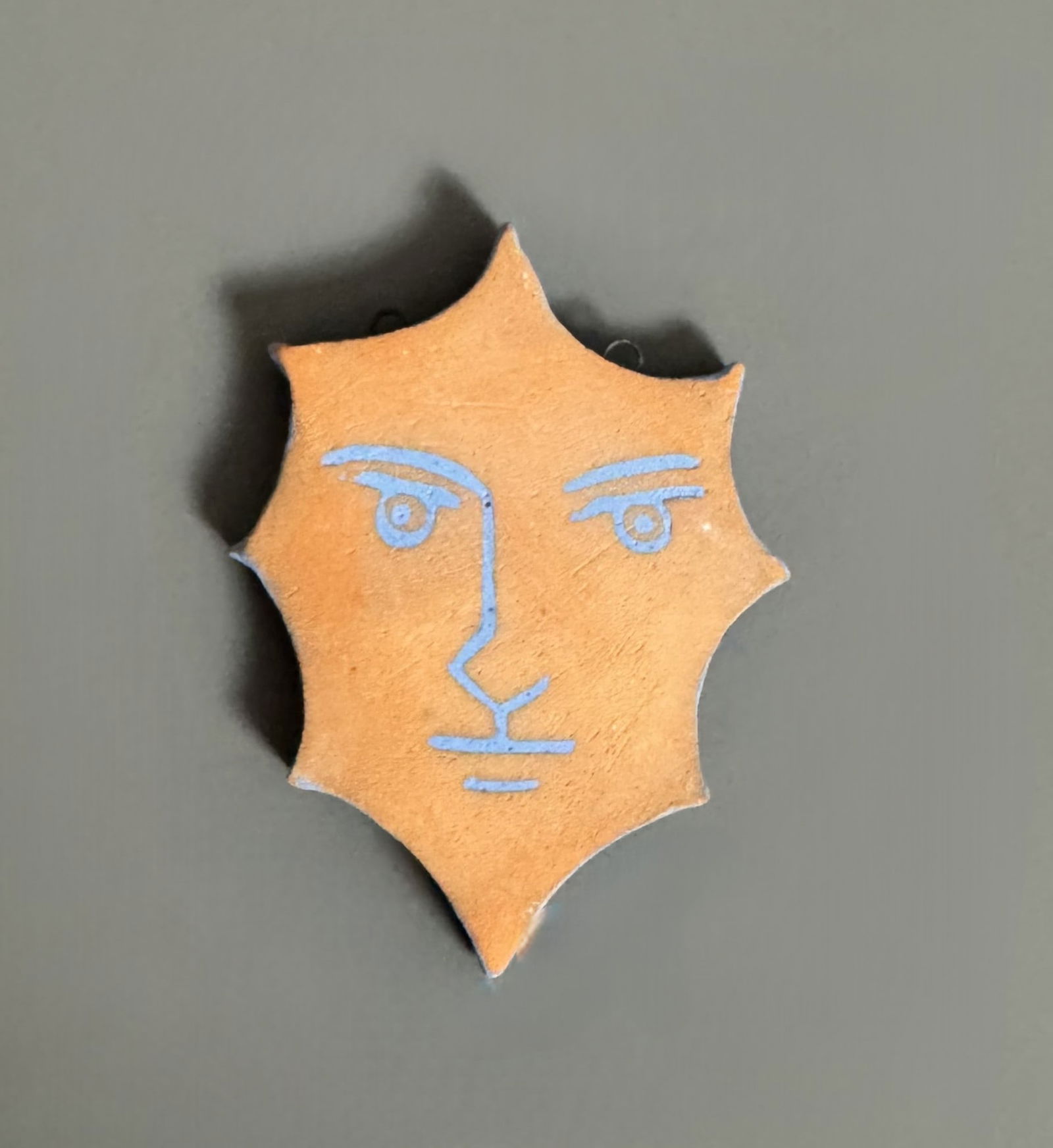 Jean COCTEAU (1958-1959) « Octogone ». 1958. 2ème variante.: Jean COCTEAU (1958-1959) « Octogone ». 1958. 2ème variante. Pendentif octogonal constitué d’une plaque découpée de céramique de terre rouge, figurant un visage