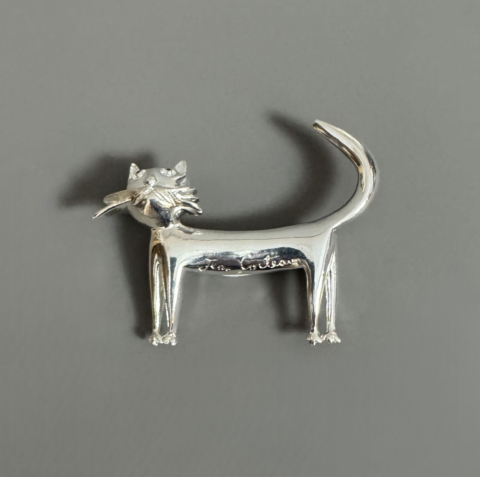 Jean COCTEAU (1889-1963) d’après. « Le chat ».: Jean COCTEAU (1889-1963) d’après. « Le chat ». Broche en métal argenté. Signé « Jean Cocteau » sur le devant. Marqué au dos Edition Madeline. Dimensi