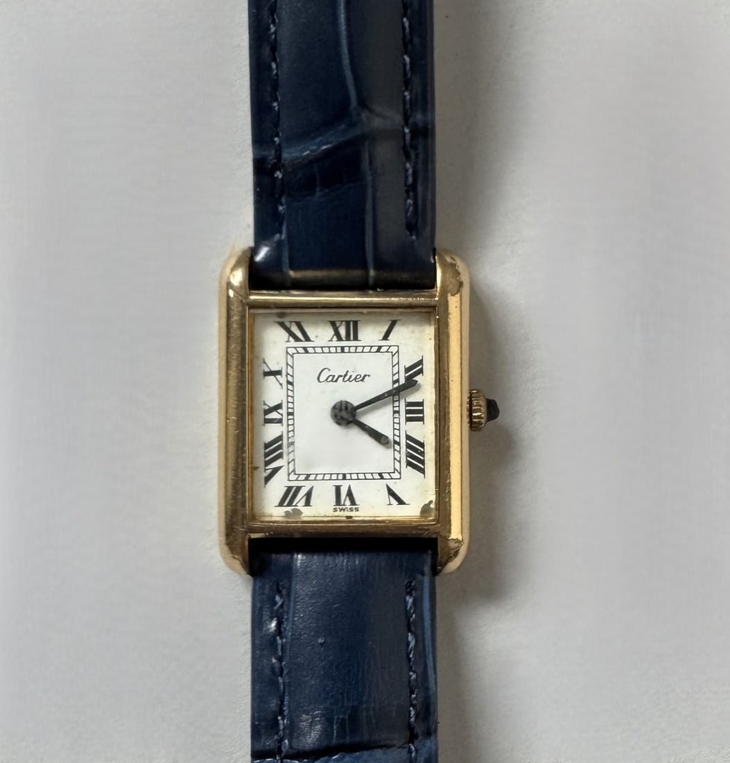 CARTIER. MontreTank. Montre bracelet pour femme en plaqué or « Electroplated l 18K »,: CARTIER. MontreTank. Montre bracelet pour femme en plaqué or « Electroplated l 18K », boîtier rectangle. Cadran peint couleur ivoire signé avec index chiffres romains. Aiguill