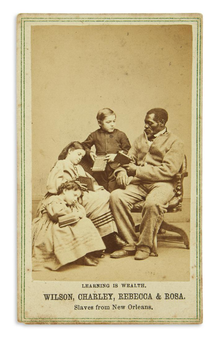(SLAVERY AND ABOLITION.) Paxson, Charles; photographer.: (SLAVERY AND ABOLITION.) Paxson, Charles; photographer. Learning is Wealth: Wilson, Charley, Rebecca & Rosa, Slaves from New Orleans. Albumen carte-de-visite photograph, 3¼ x 2 inches, on original pr
