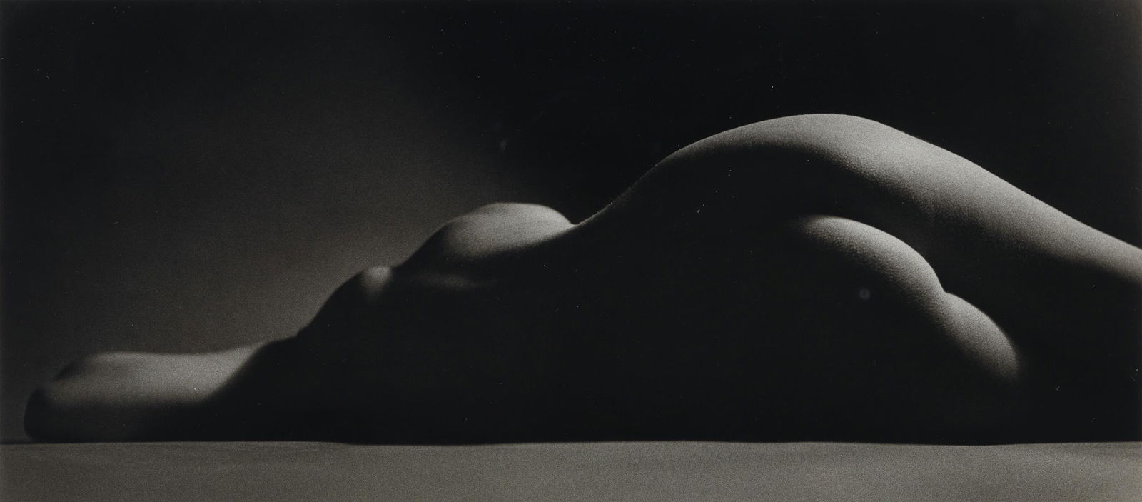 RUTH BERNHARD (1905-2006) Sand Dune.: RUTH BERNHARD (1905-2006) Sand Dune. Silver print, the image measuring 8½x19¼ inches (21.6x48.9 cm.), the mount 22x28 inches (55.9x71.1 cm.), with Bernhard's signature, in pencil, on mount r
