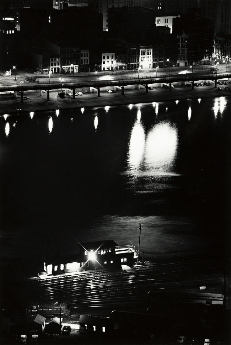 W. EUGENE SMITH (1918-1978) Pittsburgh at night from: W. EUGENE SMITH (1918-1978) Pittsburgh at night from across the river. Silver print, the image measuring 13¼x9 inches (33.6x22.9 cm.), the mount 19¾x16 inches (50.2x40.6 cm.), with Smith's E