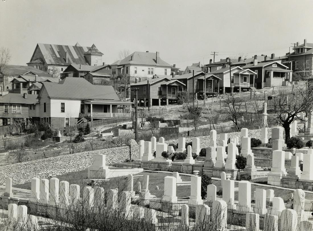 WALKER EVANS (1903-1975) Houses and Cemetery,: WALKER EVANS (1903-1975) Houses and Cemetery, Birmingham, Alabama. Silver print, the image measuring 7½x9 inches (19.1x24.4 cm.) , the sheet slightly larger, with the Lunn Archive hand stamp with