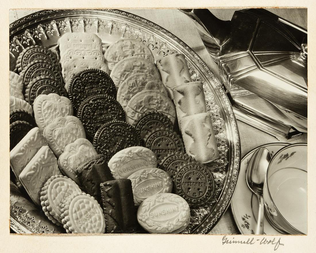 Wolf, Estelle (1886-1988) Table with Sunshine Cookies.: Wolf, Estelle (1886-1988) Table with Sunshine Cookies. Circa 1935.Silver print with Wolf's signature in pencil on mount recto, the image measuring 6 3/4 x 9 in., the mount measuring 15 3/4 x 12 1/8 in