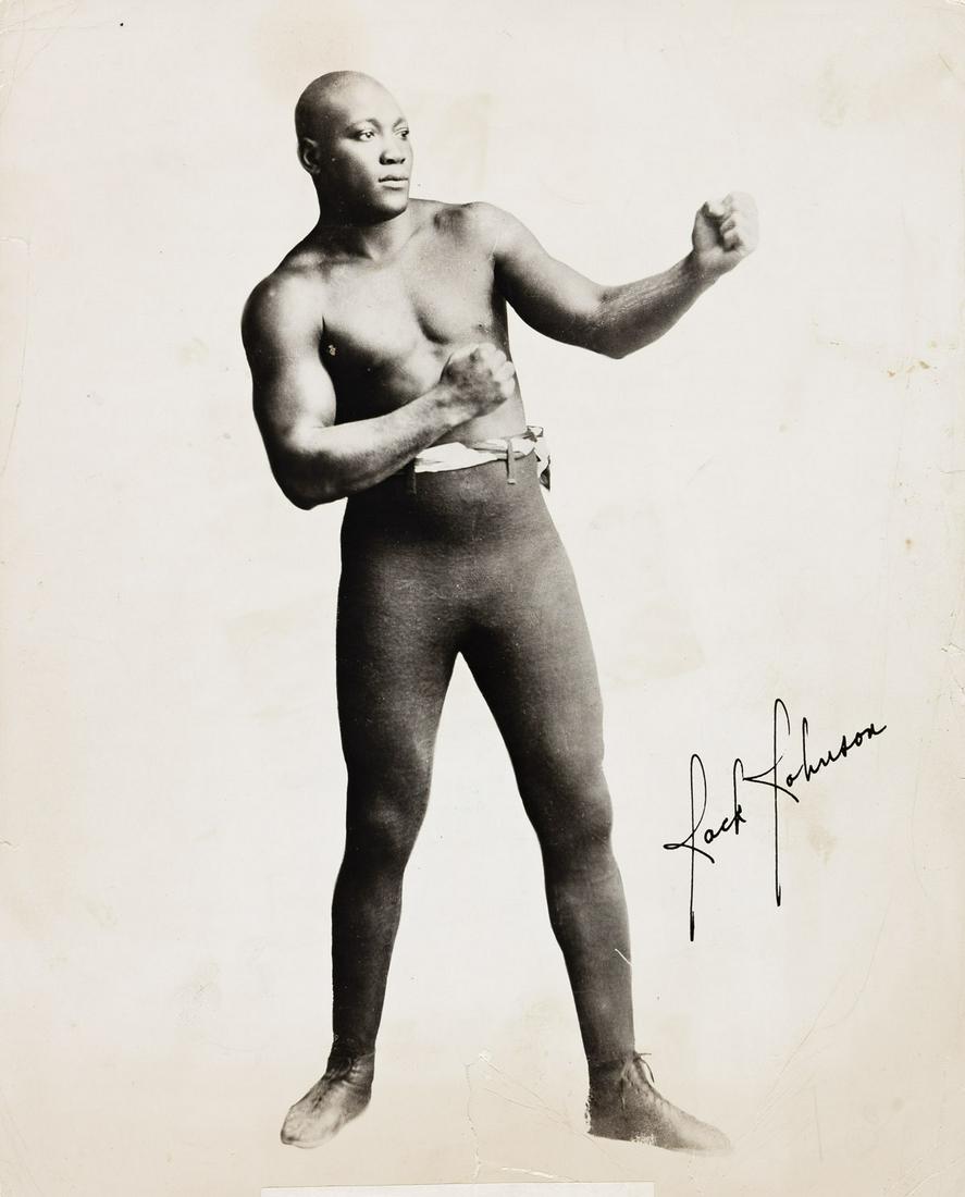 (JACK JOHNSON) Portrait of The First Black World Heavyweight Champion Boxer.: (JACK JOHNSON) Portrait of The First Black World Heavyweight Champion Boxer. Silver press print, the image measuring 10x8 inches (25.4x20.6 cm.), with a facsimile or printed signature on recto, and th