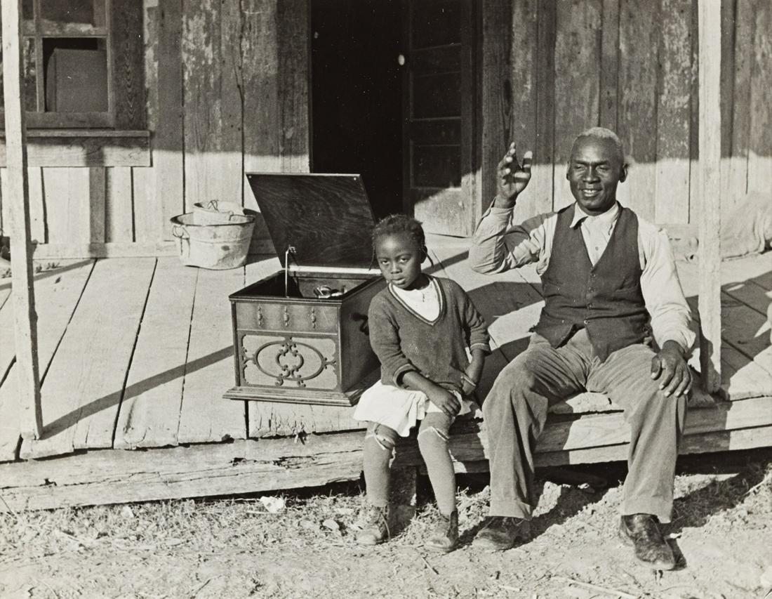 ALFRED EISENSTAEDT (1898-1995) Sharecropper Lonnie Fair and Daughter listening to Victrola,: ALFRED EISENSTAEDT (1898-1995) Sharecropper Lonnie Fair and Daughter listening to Victrola, Mississippi. Silver print, the image measuring 7¾x9 inches (17.8x22.9 cm.), with Eisenstaedt's PIX cred