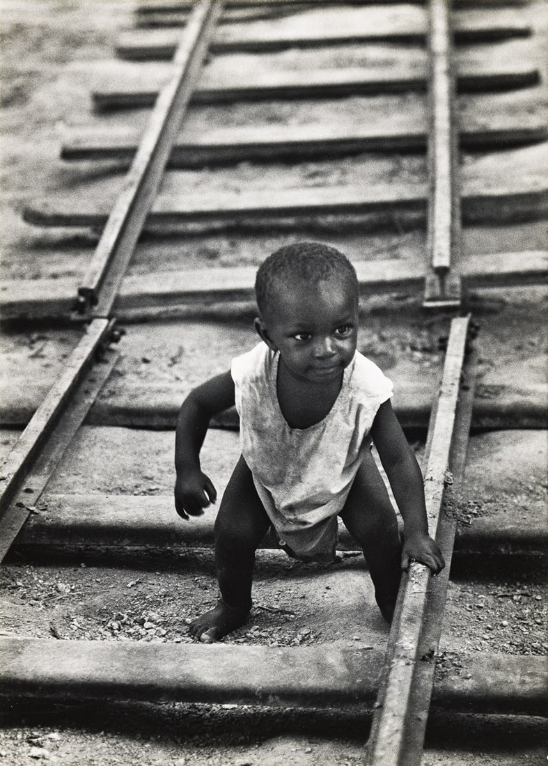 W. EUGENE SMITH (1918-1978) Baby boy on railroad track, from A Man of Mercy.: W. EUGENE SMITH (1918-1978) Baby boy on railroad track, from A Man of Mercy. Silver print, the image measuring 13¾x9 inches (34.9x25.1 cm.), the mount 20x16 inches (50.8x40.6 cm.), with Smith's C