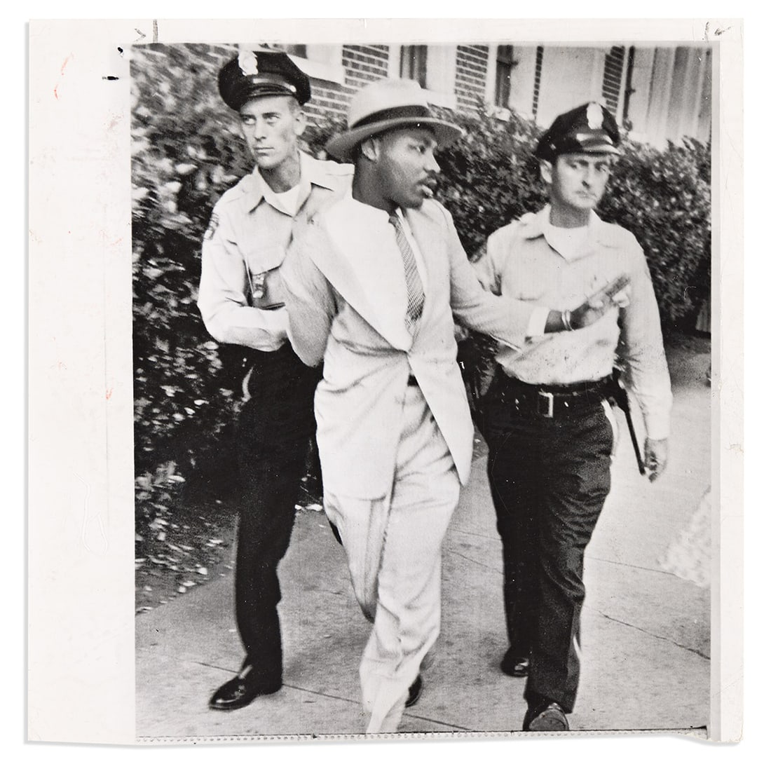 (MARTIN LUTHER KING.) [Charles Moore, photographer.] Wire photo of King's arrest in Montgomery.: (MARTIN LUTHER KING.) [Charles Moore, photographer.] Wire photo of King's arrest in Montgomery. Wire photo, 8 x 8 inches, with 1958 newspaper clippings and inked stamps on verso; caption area at botto