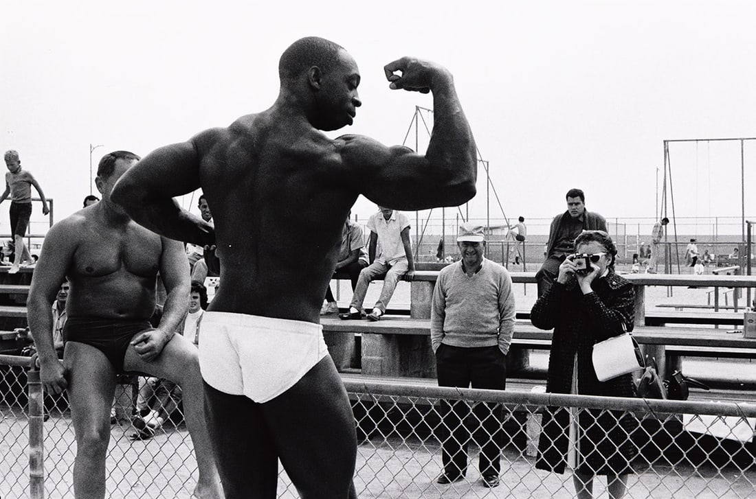 BRUCE DAVIDSON (1933- ) Muscle Beach.: BRUCE DAVIDSON (1933- ) Muscle Beach. Silver print, the image measuring 6¾x10 inches (17.1x25.4 cm.), the sheet 11x14 inches (27.9x35.6 cm.), with a copyright label with Davidson's signature and