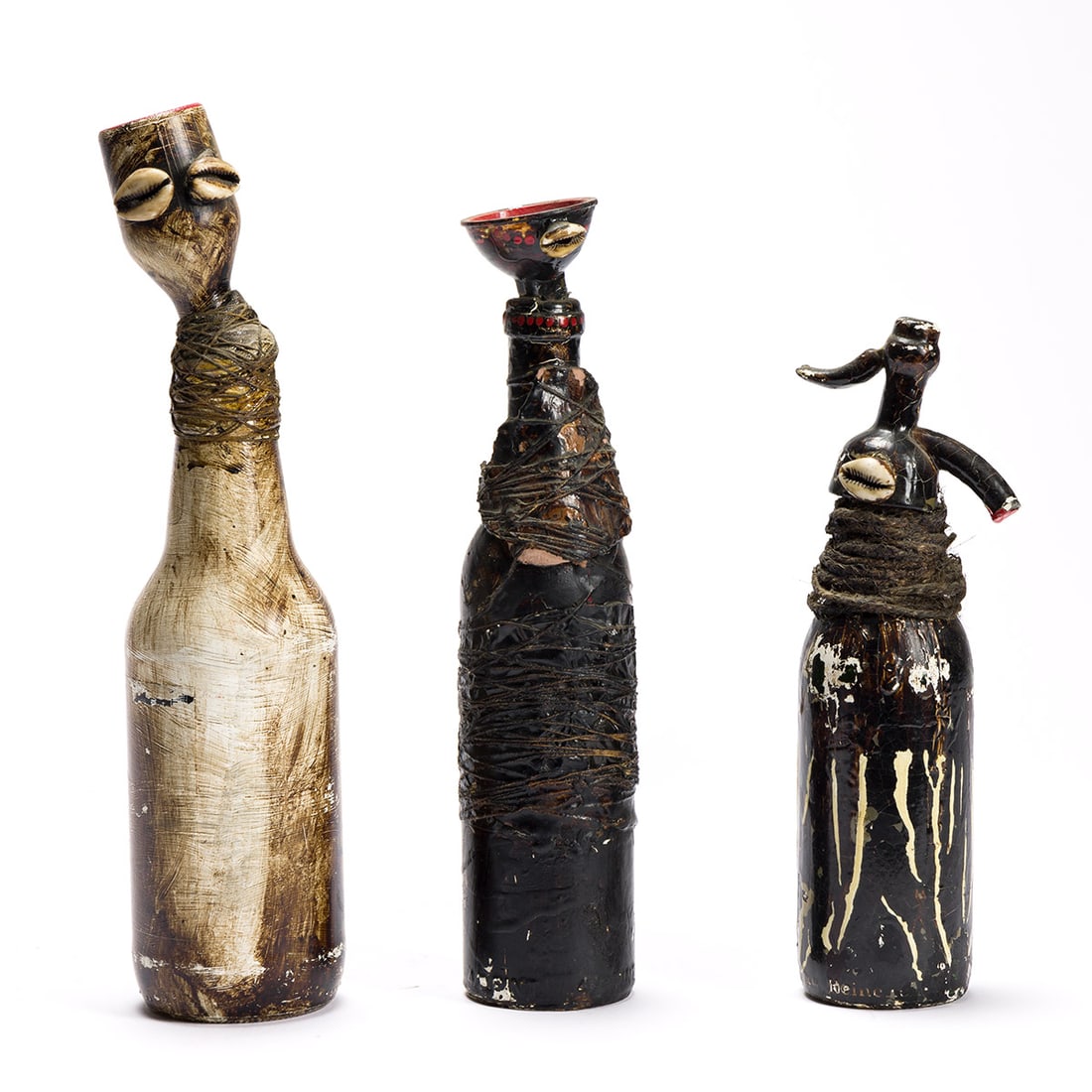 WANGECHI MUTU (1973 - ) Three from the Bottle People Series.: WANGECHI MUTU (1973 - ) Three from the Bottle People Series. Three mixed media and glass sculptures, 1997. Approximately 318x70 mm, 279x64 mm and 248x64 mm; 12½x2¾ inches, 11x2½ inches
