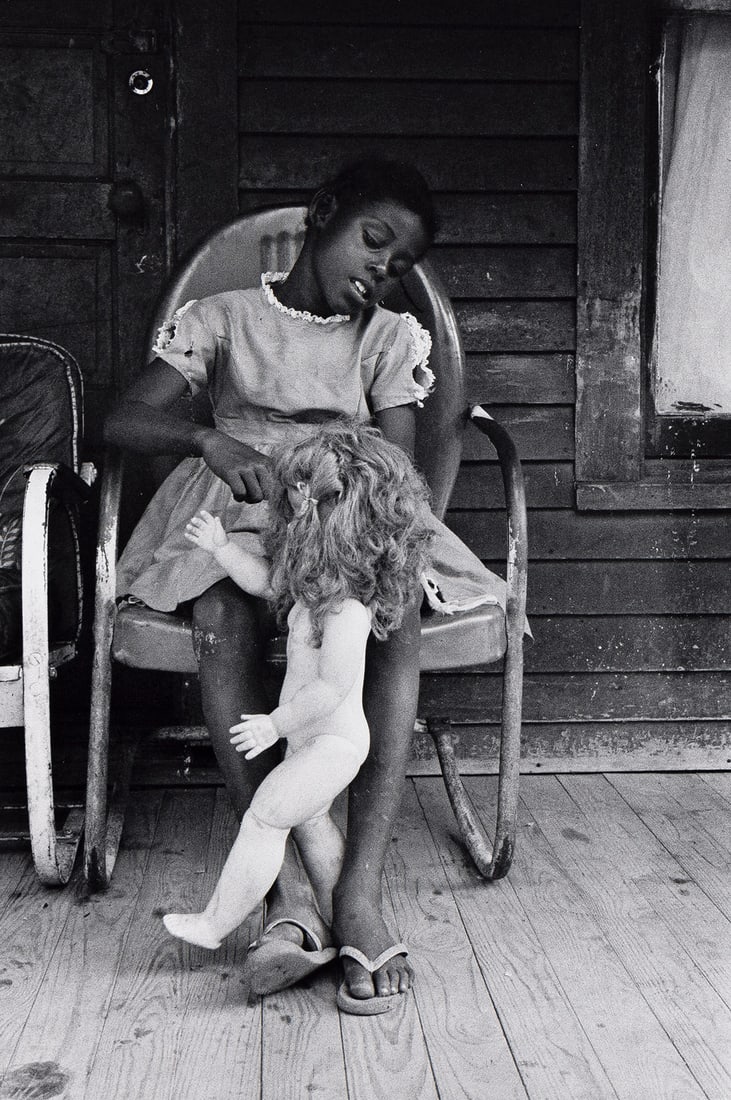 BRUCE DAVIDSON (1933- ) Child on a Front Porch Playing with her Doll Baby, Shelby County, Tennessee.: BRUCE DAVIDSON (1933- ) Child on a Front Porch Playing with her Doll Baby, Shelby County, Tennessee. 1962; printed 1999. Silver print, the image measuring 10x6¾ inches (25.4x17.1 cm.), the sheet