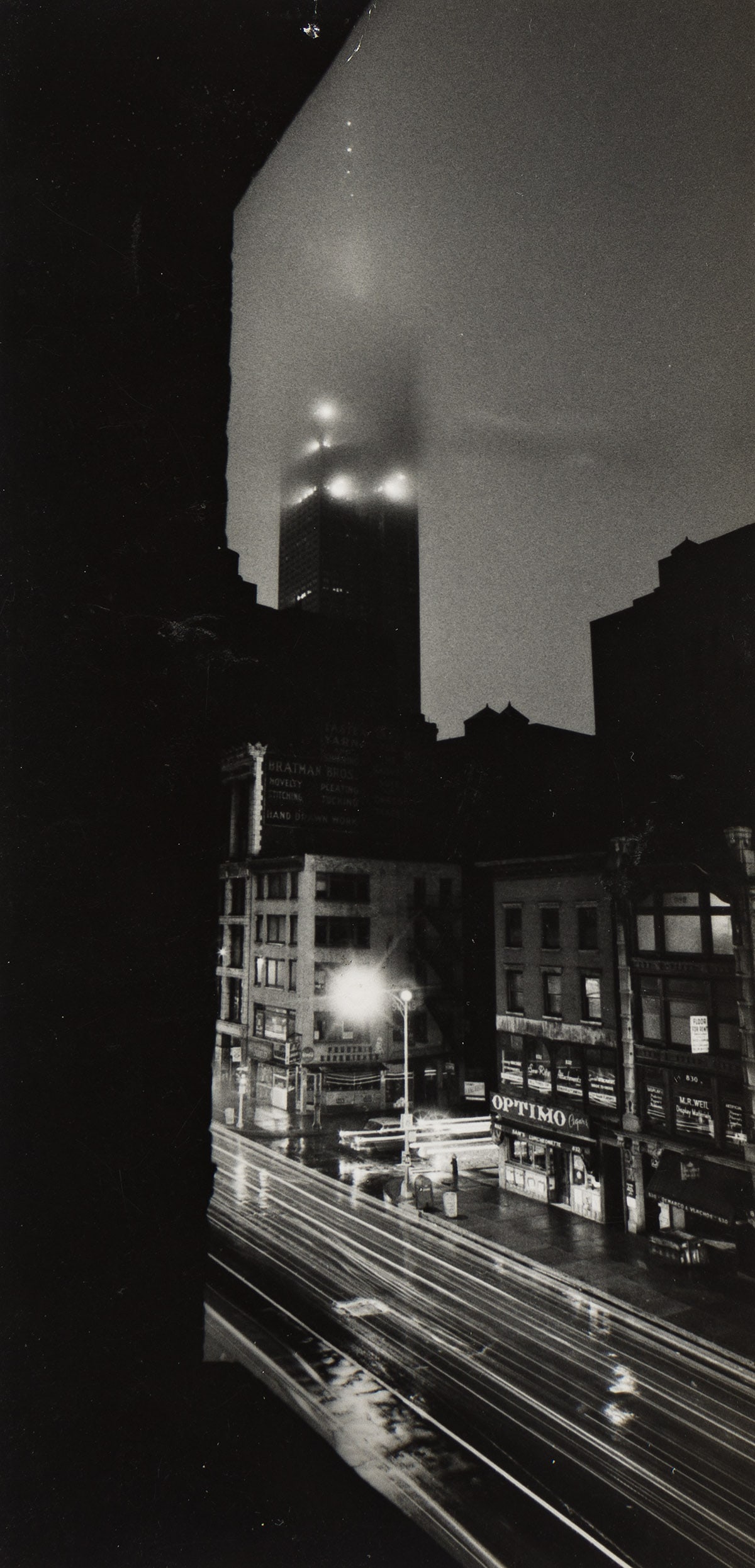 W. EUGENE SMITH (1918-1978) Empire State Building, New York City. Circa 1955-58.: W. EUGENE SMITH (1918-1978) Empire State Building, New York City. Circa 1955-58. Silver print, the image measuring 6x2⅞ inches (15.2x7.3 cm.), with two of Smith's credit stamps and numeric notat