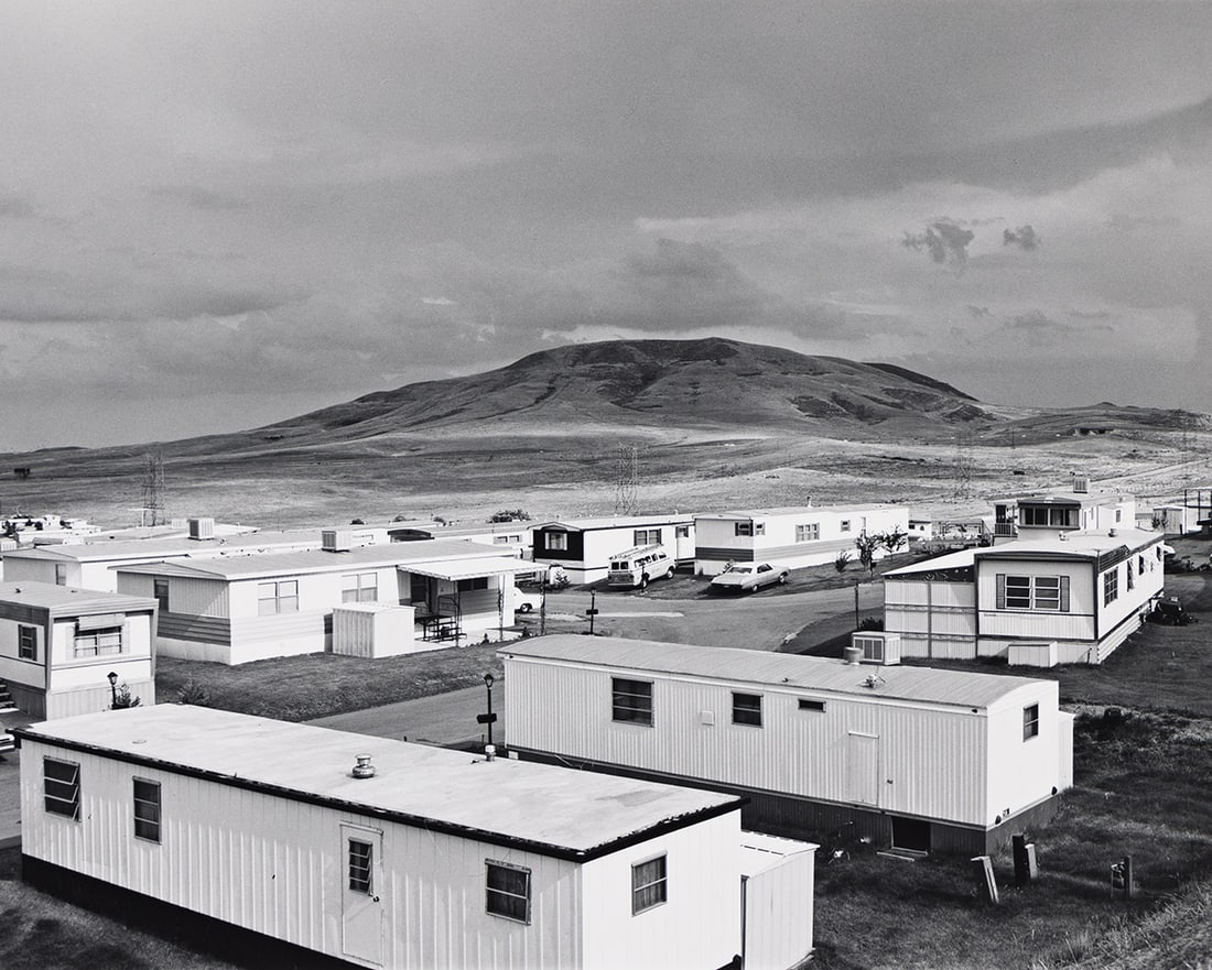 ROBERT ADAMS (1937- ) Mobile homes, Jefferson County, Colorado. 1973.: ROBERT ADAMS (1937- ) Mobile homes, Jefferson County, Colorado. 1973. Silver print, the image measuring 6x7⅜ inches (15.2x18.7 cm.), the mount 15½x14 inches (39.4x35.6 cm.), with Adams' han