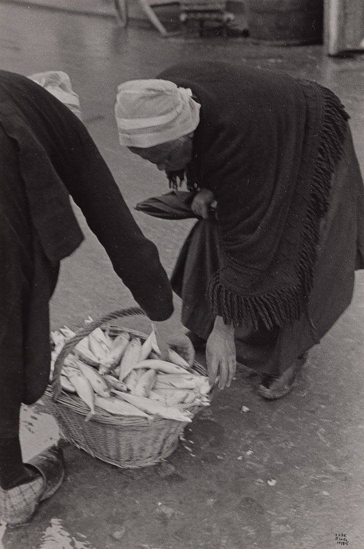 ILSE BING (1899-1998) Bretagne, women with fishing in basket. 1935.: ILSE BING (1899-1998) Bretagne, women with fishing in basket. 1935. Silver print, the image measuring 8½x5⅝ inches (21.6x14.3 cm.), the mount 13x10½ inches (33x26.7 cm.), with Bing's s