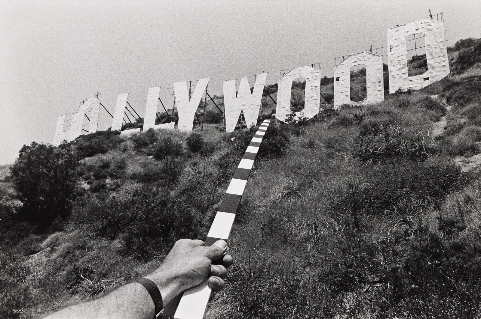 Kenneth Josephson. Hollywood, from the Archaeological series, Two Meter Stick. 1975.: Kenneth Josephson1932-Hollywood, from the Archaeological series, Two Meter Stick. 1975.Silver printWith Josephson's signature, title, date, and numeric notation in pencil on verso.The image 8 x 12 in.