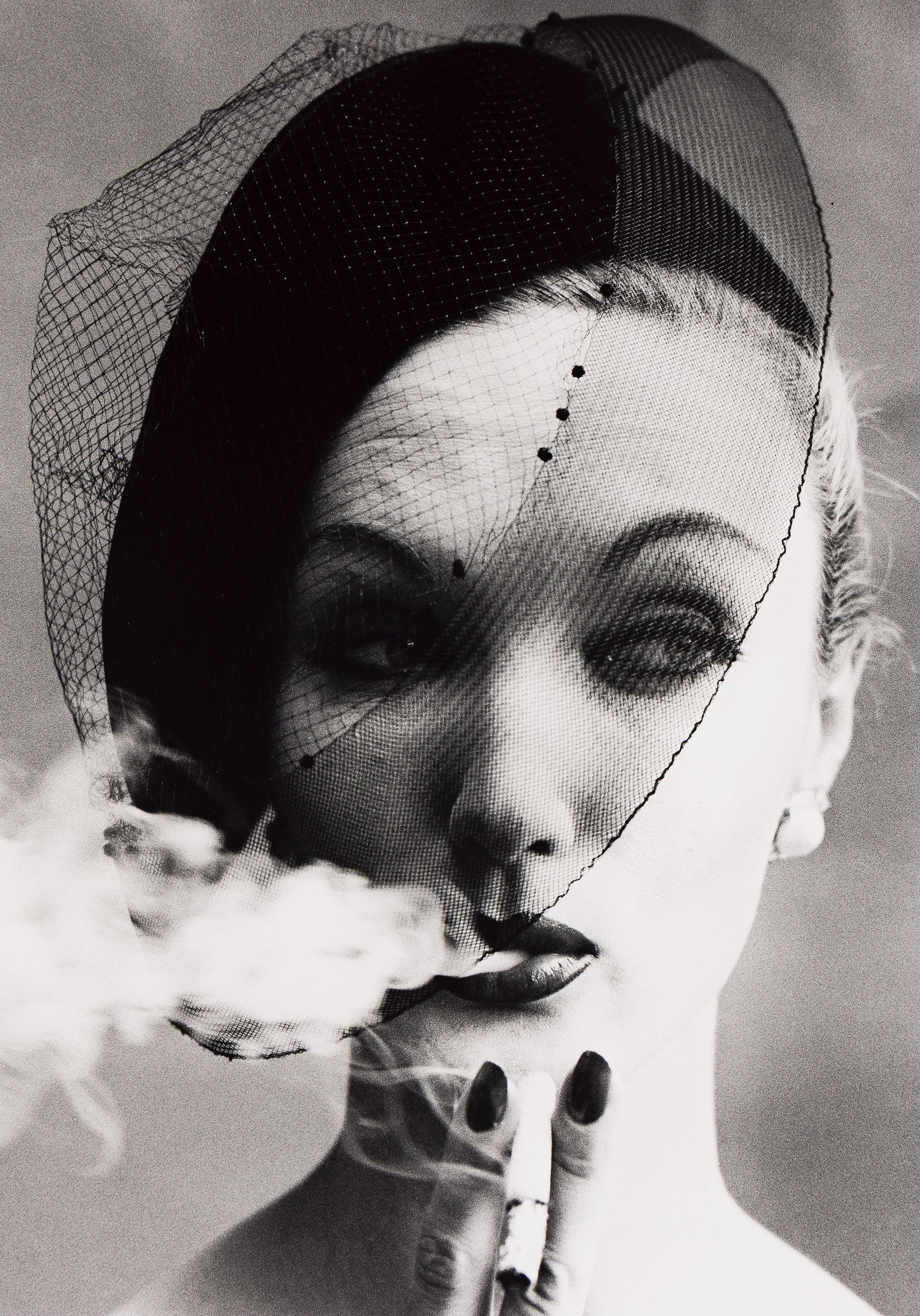 William Klein. Smoke + Veil, Paris (Vogue). 1958; printed later.: William Klein1928-2022Smoke + Veil, Paris (Vogue). 1958; printed later.Silver printWith Klein's signature, title, and negative date in pencil on verso.The image 22 3/8 x 15 3/4 in. (56.8 x 40 cm.), th