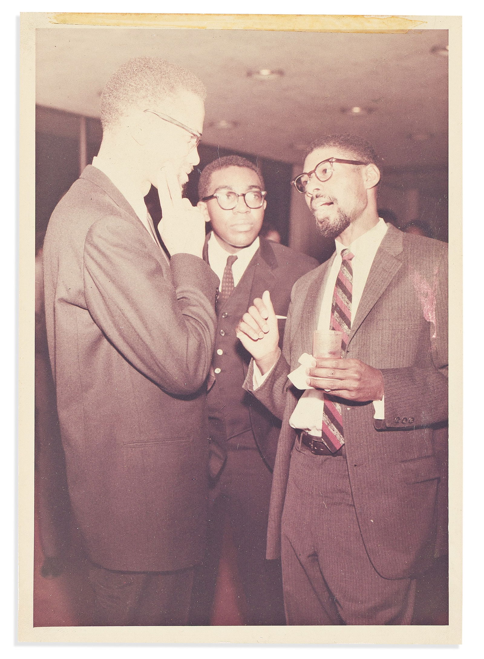 (MALCOLM X.) Photograph of Malcolm X with two associates. No place, circa 1964 (1 of 1)