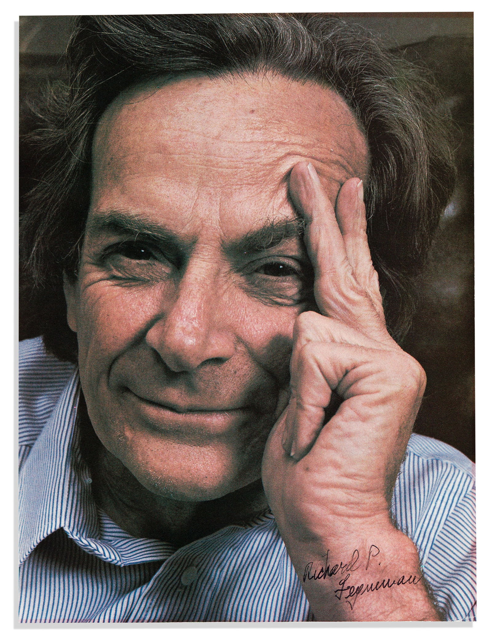 (Nobel Laureates--Physics.) Richard Feynman. Color Photograph Signed: Richard Feynman Color Photograph Signed, bust portrait clipped from a magazine, showing him resting his head on one hand and looking into the camera. Signed in the image at lower right. 10½x8 inc