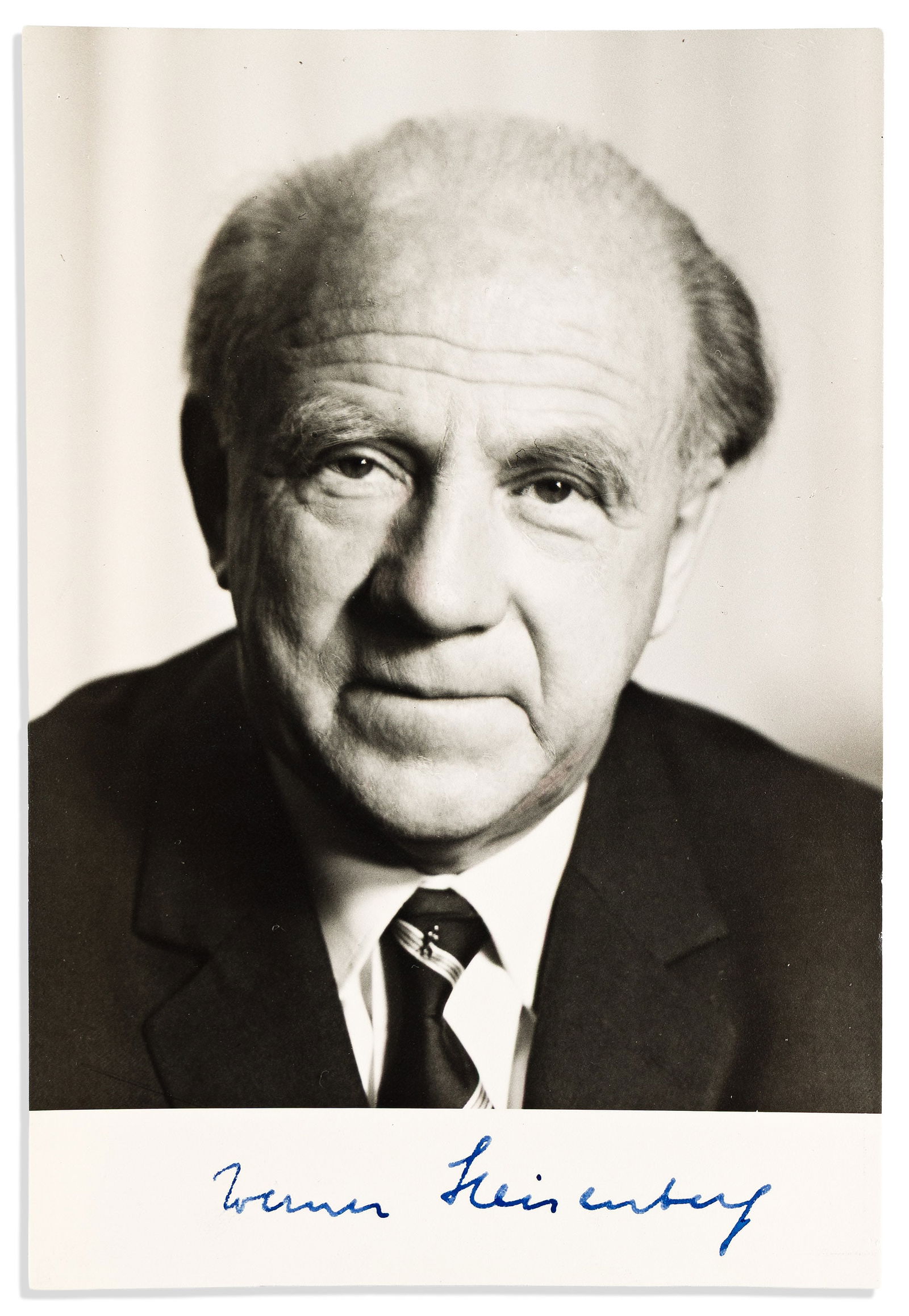 (Nobel Laureates--Physics.) Werner Heisenberg. Photograph Signed: Werner Heisenberg Photograph Signed, bust portrait by Tita Binz, showing him looking just above the camera. Signed in the blank lower margin. 6½x4¼ inches; remnants of cello tape at upper an