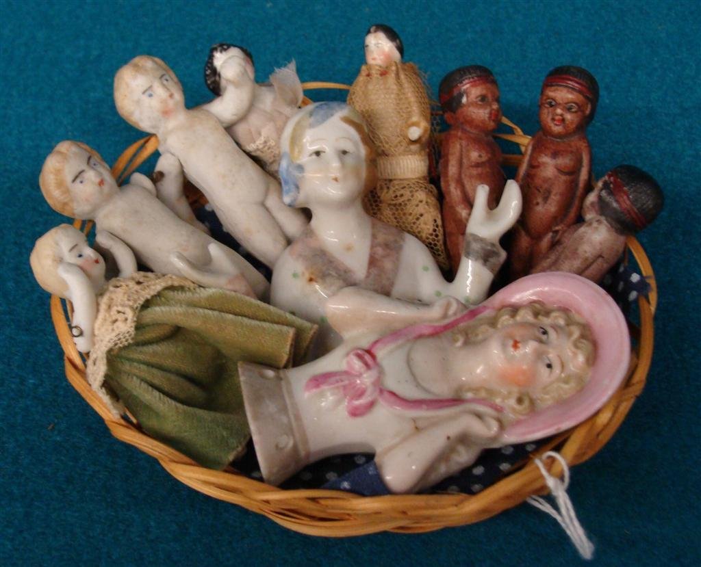 Basket Full of Dolls: Includes Antique Frozen: Basket Full of Dolls: Includes Antique Frozen Charlottes, Art Deco Half Doll and Doll in Black Checkered Dress. Auction Estimate $100-200.