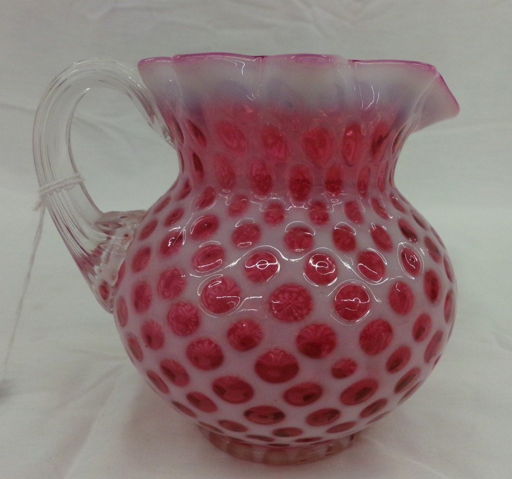 Cranberry Opalescent Art Glass Pitcher with Ruffled Top: Cranberry Opalescent Art Glass Pitcher with Ruffled Top Applied Clear Handle & Thumbprint/Coin Dot Design. Auction Estimate $50-100.