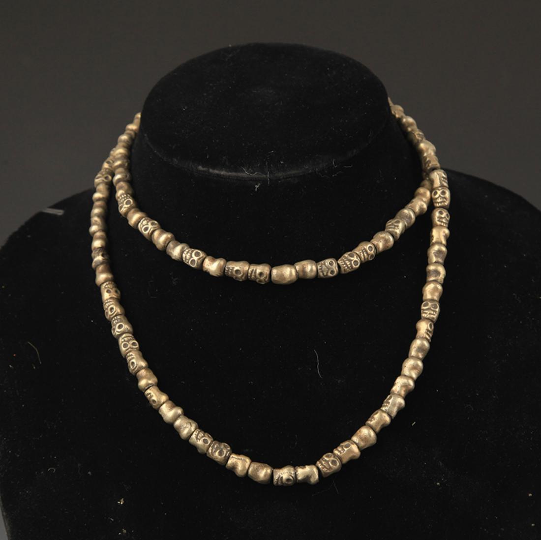 A FINELY CARVED BRONZE SKULL NECKLACE (1 of 3)