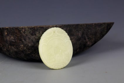A FINELY CARVED HETIAN PALE CELADON JADE PENDANT