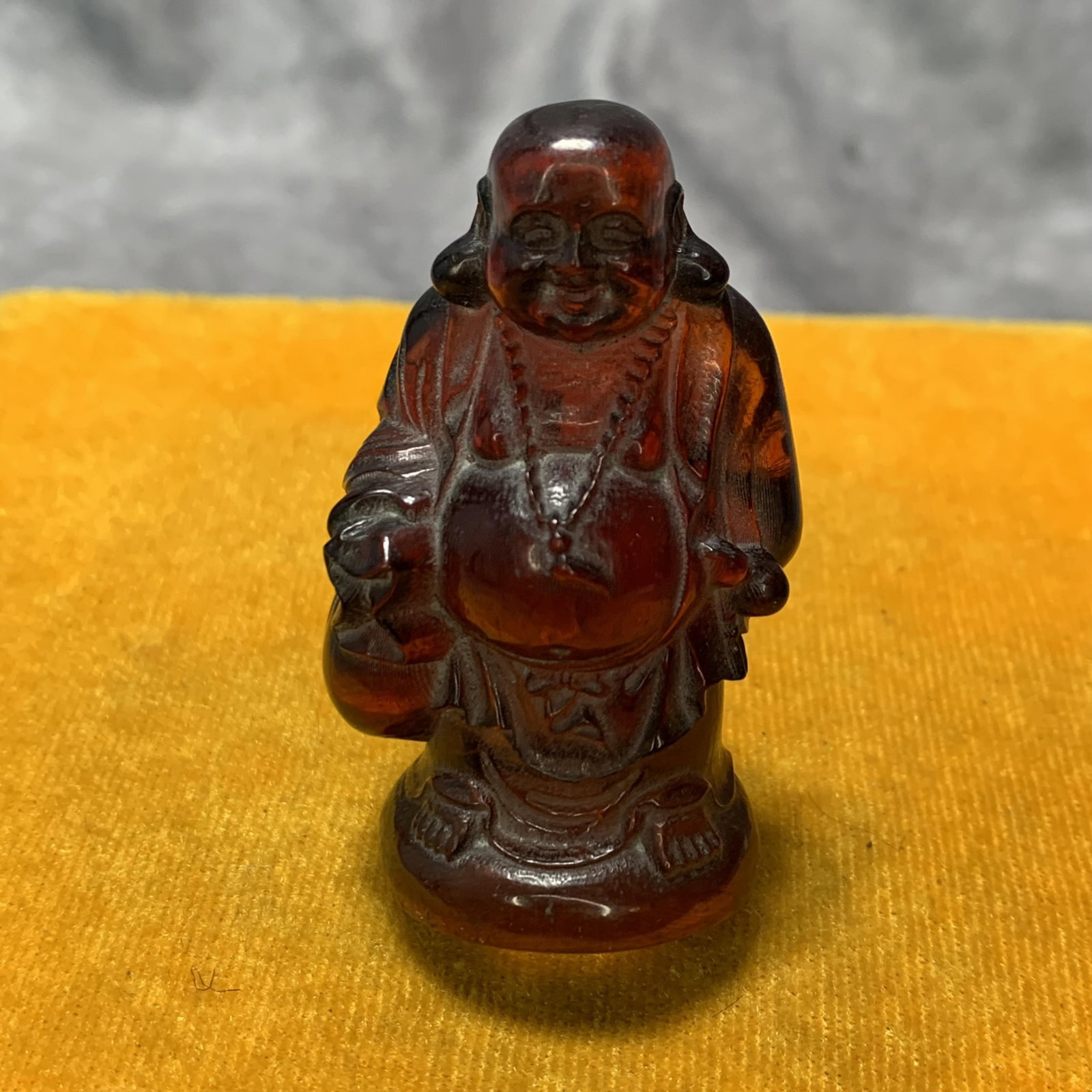 A SMALL AMBER MADE MAITREYA BUDDHA: Republic Period; Long: 1.3 inch; Width: 1 inch; High: 2.4 inch