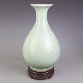 A FINE BEAN GREEN GLAZED CARVED FLOWER PATTERN PORCELAIN BOTTLE