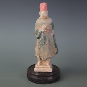 A SMALL TRI-COLOR CERAMIC FIGURINE