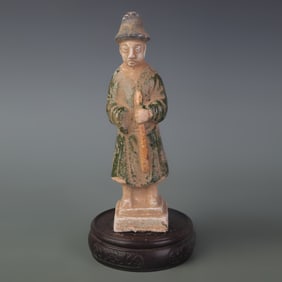 A SMALL TRI-COLOR CERAMIC FIGURINE