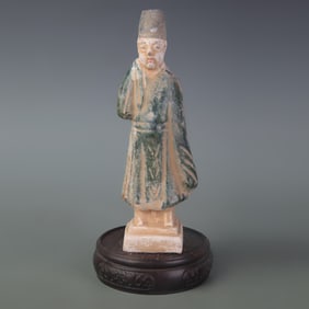 A SMALL TRI-COLOR CERAMIC FIGURINE