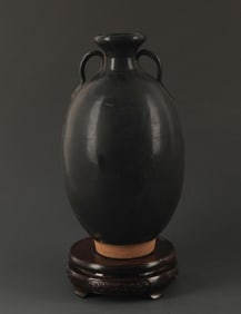 A BLACK GLAZED TWO TILE POTTERY JAR
