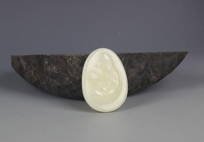 A FINELY CARVED HETIAN PALE CELADON JADE PENDANT