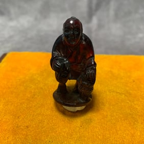 A SMALL AMBER MADE BUDDHA PENDANT