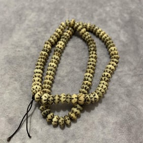 A FINELY CARVED COW BONE MADE NECKLACE