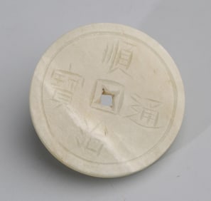 A FINE PALE CELADON JADE COIN FIGURE PENDANT