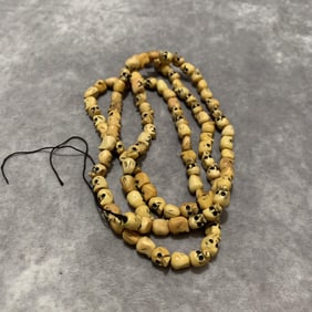 A FINELY CARVED COW BONE MADE NECKLACE