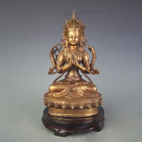 A SMALL BRONZE FOUR-ARMED GUANYIN
