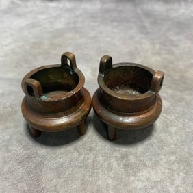 PAIR OF COPPER TRIPOD CENSERS WITH VERTICAL HANDLES AND “BUDDHA?? MARK