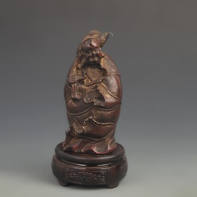 A FINE CARVED LACQUER AND LOTUS LEAF CHILD WOOD FIGURE