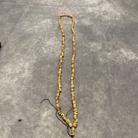 A FINELY CARVED COW BONE MADE NECKLACE