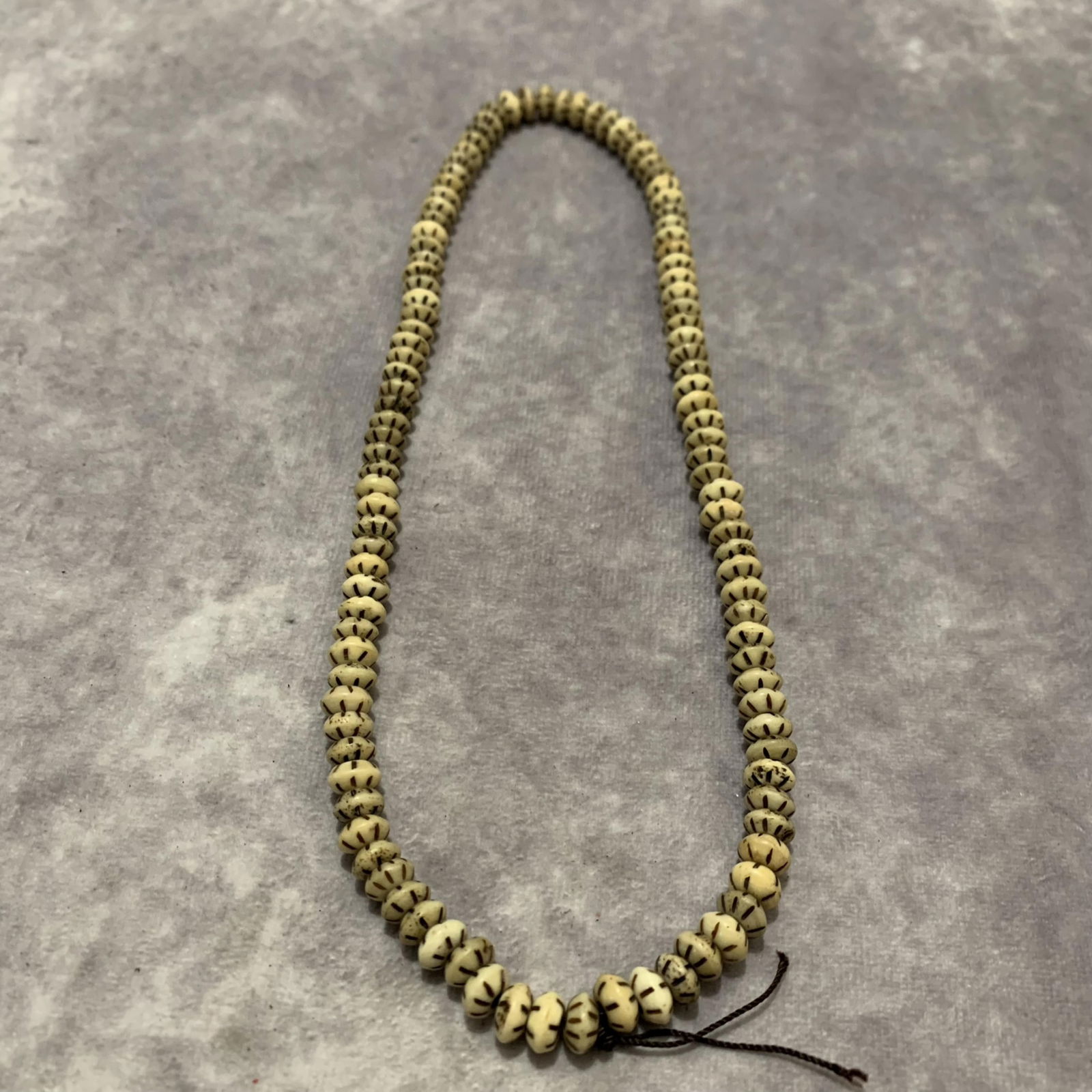 A FINELY CARVED COW BONE MADE NECKLACE: Modern; Long: 10 inch;