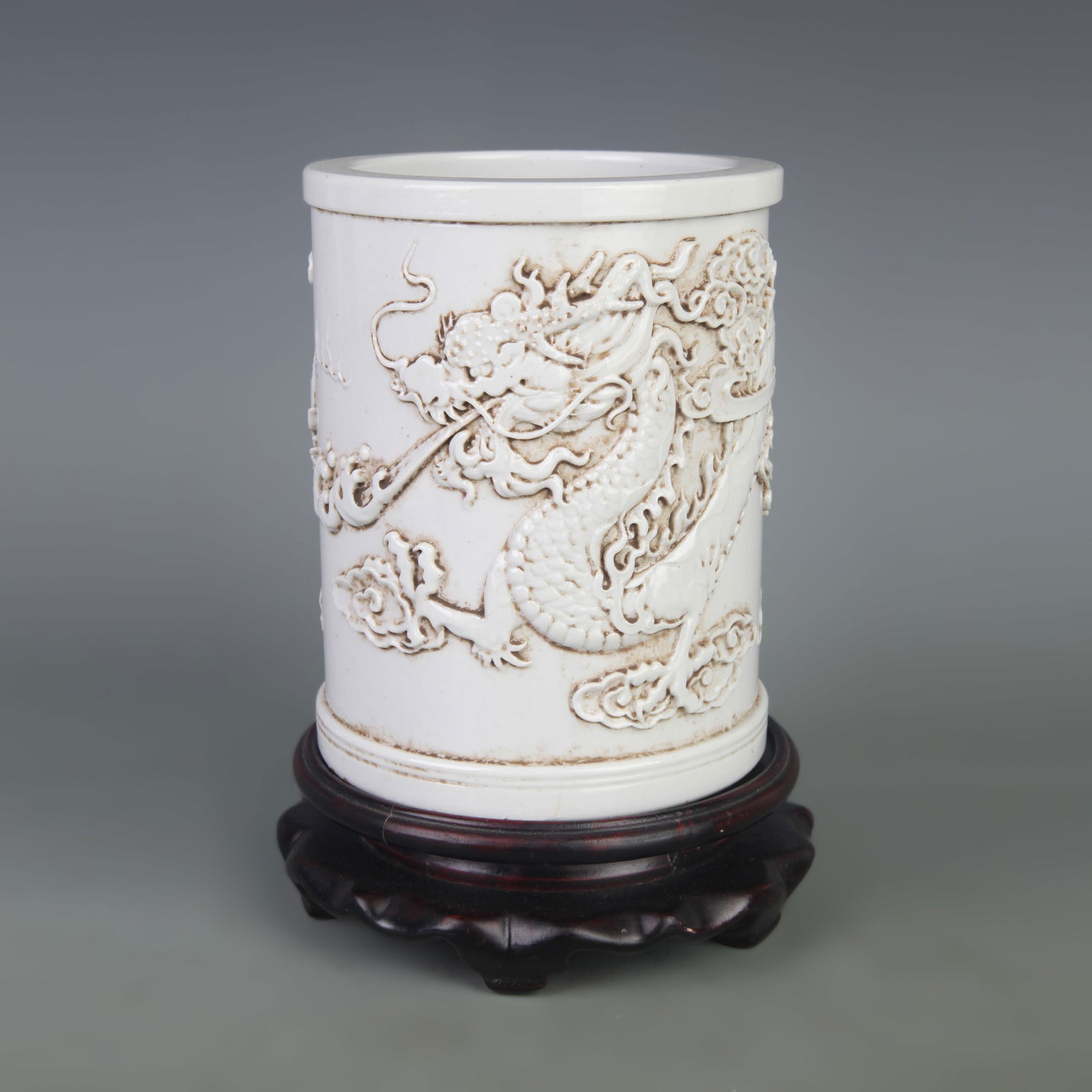 WHITE PORCELAIN CARVED DRAGON BRUSH POT: Qing Dynasty; Diameter: 4.4 inch; High:5.5 inch