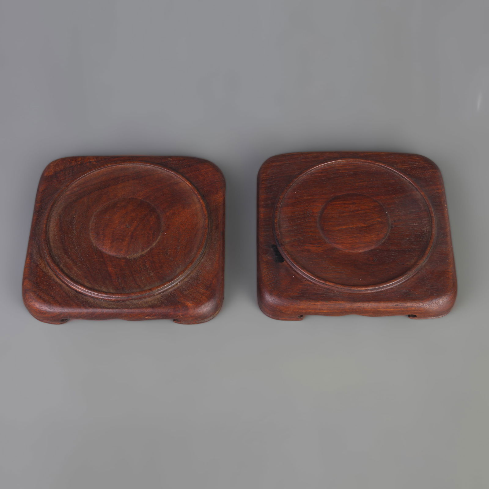 SET OF TWO WOODEN STANDS: Modern; Long: 5.7 inch; to 5.8 inch; Width: 5.5 inch; to 5.7 inch; High: 0.6 inch; to 0.8 inch;